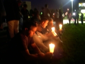 Young people pray in candlelight.